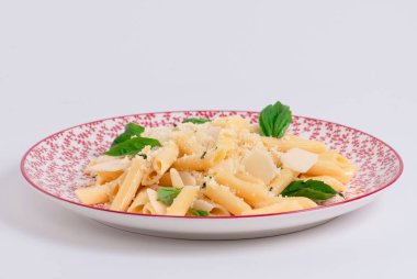 Seçici odaklanma ve hafif arka planda güzel bir tabakta peynirli ve otlu yeni pişirilmiş makarnayı kapat. Makarna ve lezzetli yemek konsepti.