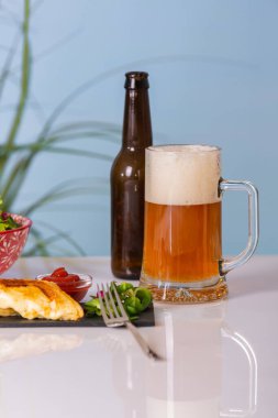 Bira bardağı, boş bira şişesi ve ızgara sandviç.