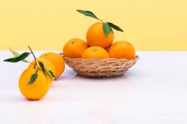 Yapraklı sepetteki lezzetli portakallar