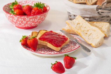 Çilek reçeli, taze çilek ve tabakta bıçak.