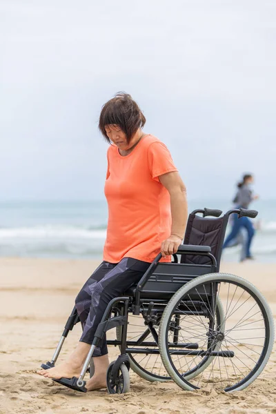 アジアの女性は、 covid-19に感染した後、回復演習を行うために車椅子から立ち上がる — ストック写真
