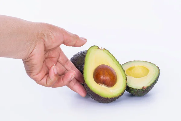 Hand vidröra en avokado skära i hälften: Selektiv fokus och närbild. Friska livsmedel. — Stockfoto