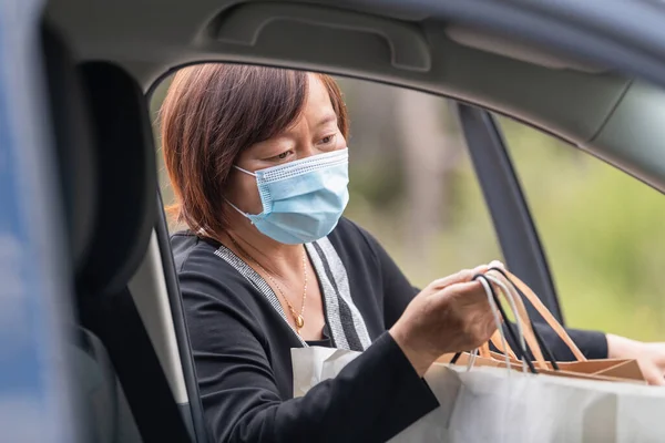 Primer plano de mujer asiática madura poniendo bolsas de compras dentro de su coche — Foto de Stock