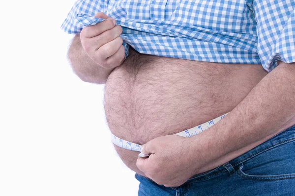 Толстяк проверяет свой жир с помощью измерительной ленты: избирательный фокус. Концепция избыточного веса и ожирения — стоковое фото