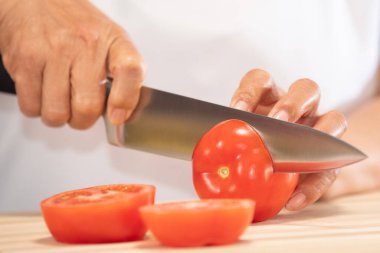 Taze domates kesen kadın: Seçici odaklanma. Diyet ve sağlıklı gıda konsepti