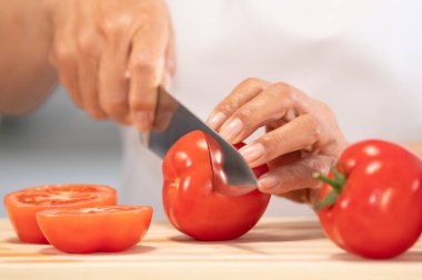Taze domates kesen kadın: Seçici odaklanma. Diyet ve sağlıklı gıda konsepti