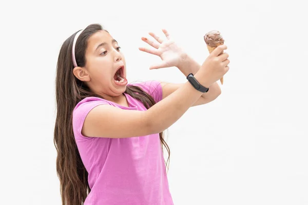 Menina segurando um cone de sorvete de chocolate brincando: Foco seletivo. Conceito de sorvete. — Fotografia de Stock