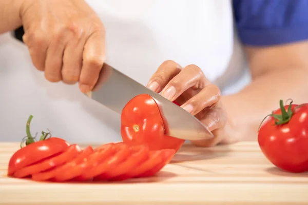 Kvinna skära färsk tomat: Selektivt fokus. Kost och hälsosam mat koncept — Stockfoto