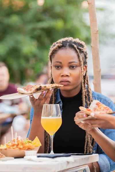Afroamerikanerin hält ruhig ein Stück Pizza in der Hand — Stockfoto