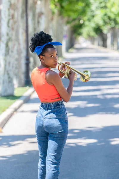 Foto trasera de mujer latina lista para tocar una trompeta — Foto de Stock