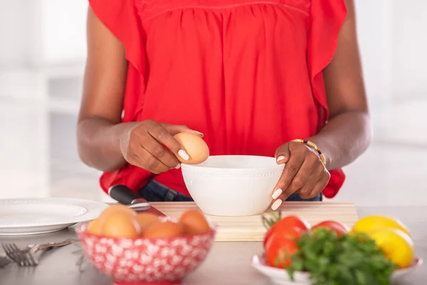 Zblízka afro americká žena drží vejce na okraji mísy — Stock fotografie