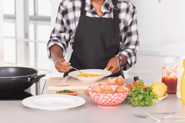 Una donna afro-americana esperta che sbatteva uova su un piatto d'argento. Concetto cucina — Foto Stock