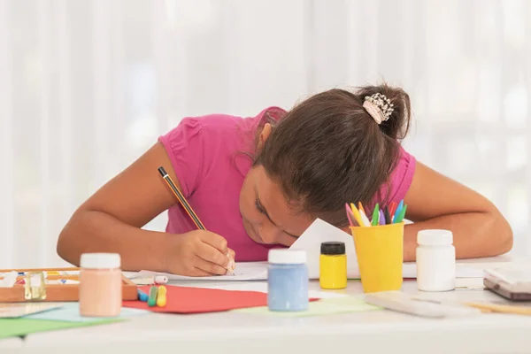 Zicht op een klein meisje genieten van tekenen in de kunstklas Stockafbeelding