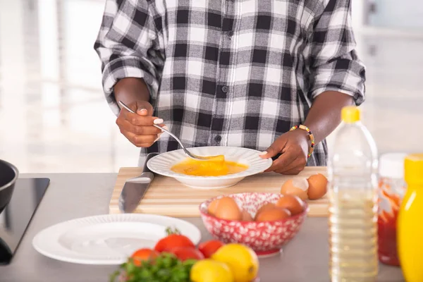 Primo piano della donna afro-americana che sbatteva le uova con una forchetta: concetto di cucina — Foto Stock