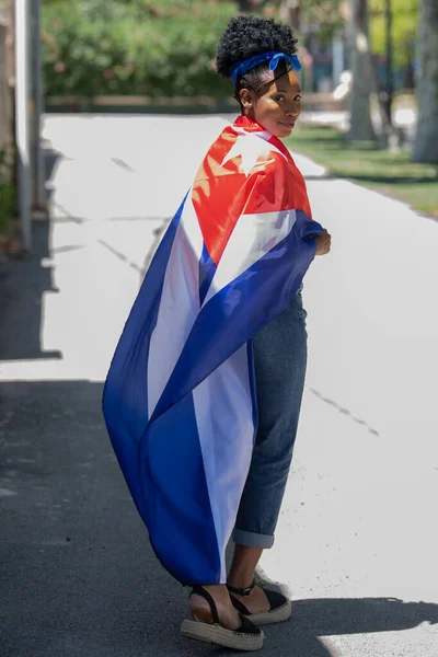 Közelkép egy latin nőről, aki kubai zászlót visel, és mosolyog a kamerába. — Stock Fotó