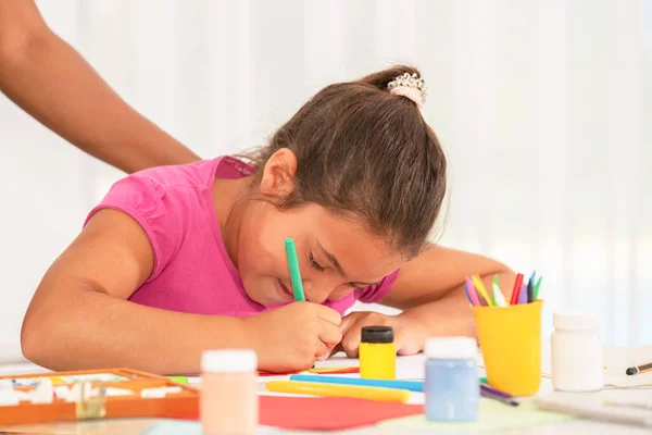 Вид маленької дівчинки, яка насолоджується малюнком з кольоровими олівцями — стокове фото