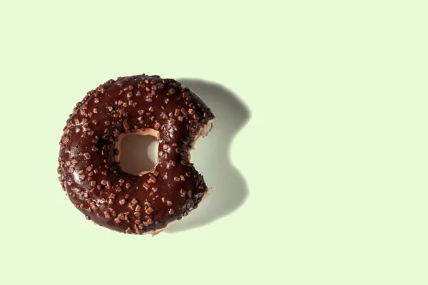 Vista Perto Donut Chocolate Mordido Fundo Verde Isolado Conceito Alimentação — Fotografia de Stock