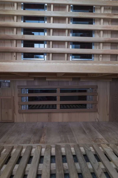 Infrared sauna interior close up view. Wooden walls and bench, ceramic heaters. Healthy lifestyle concept.