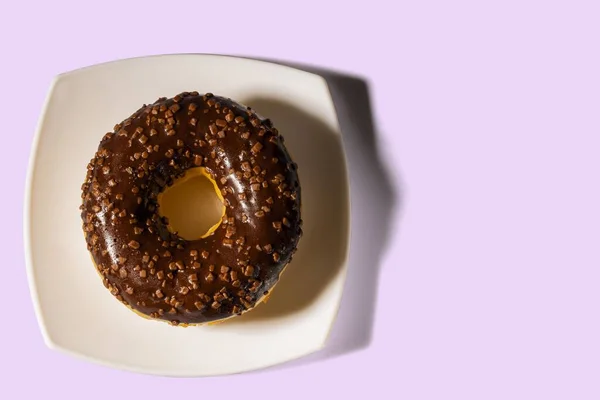 화이트 플레이트와 배경에 초콜릿 도넛이 모습을 가까이서 수있다 식품과 — 스톡 사진