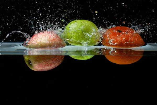 Vista Cerca Frutas Colores Que Caen Agua Sobre Fondo Negro — Foto de Stock