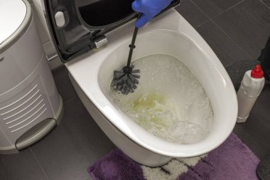 Klozet kapağını temizleyen mavi eldivenli erkek elleri yakın çekim. Hijyen kavramı. 