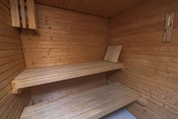 Close up view of sauna room interior. Wooden walls and seats. Health concept.