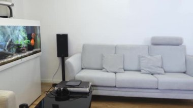 Modern oturma odasının güzel manzarası. Beyaz şömine, beyaz duvar arkasında açık renkli mobilyalar..