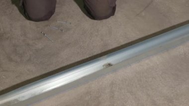 Metal parmaklıklara çivi çakan erkek işçi görüntüsü. İnşaat konsepti.