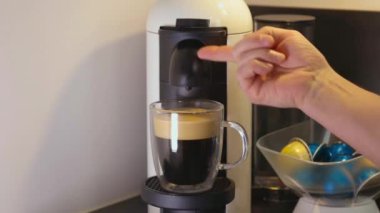 Kahve demleme sürecinin sonuna yakın çekim. Nescafe makinesinden kapsül boşaltılıyor.