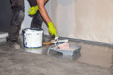 Boyama işini yapan erkek işçinin yakın görüntüsü. İnşaat konsepti.