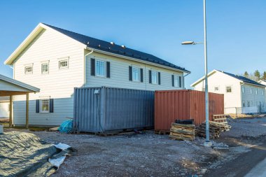 Mavi arka planda yapım aşamasındaki beyaz ahşap evin güzel manzarası. İsveç.