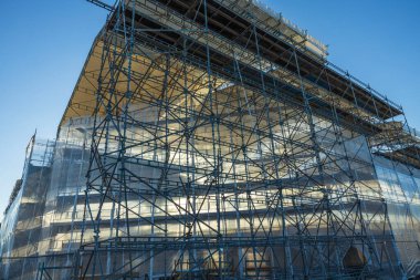 Mavi gökyüzü arka planında inşaat halindeki manzaralı binayı kapatın. Endüstri kavramı.