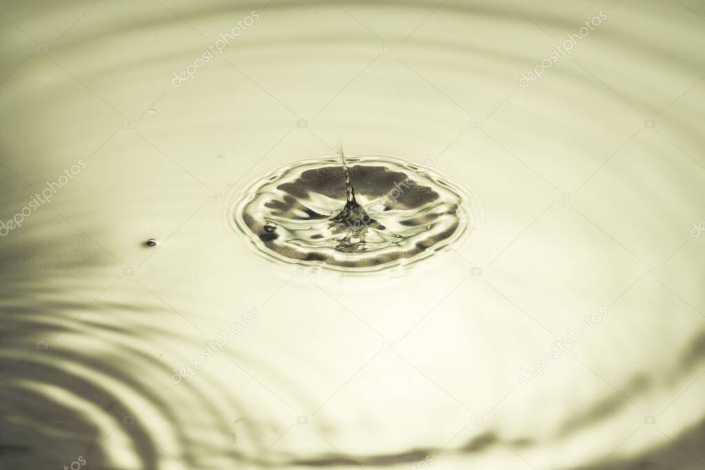 Close up view of drops making circles on water surface isolated on background.