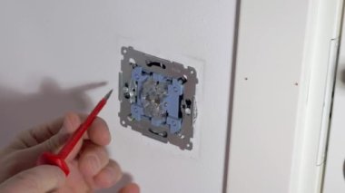 Beyaz ışık düğmesini tamir eden adamın görüntüsü. Elektrik konsepti. İsveç.