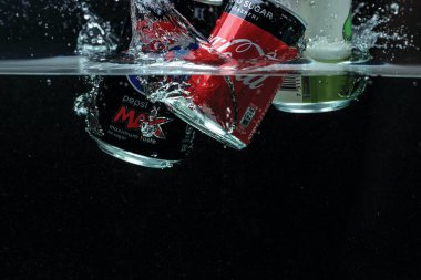 İki teneke kutunun suya düşüşünü yakından izle. Coca Cola, Pepsi Cola 'ya karşı. İsveç. Uppsala. 03.26.2021.
