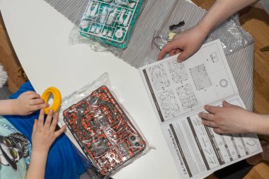 Çocuk ve erkeğin yeni oyun için el ele tutuşmalarını yakından izleyin. Çocukluk ve ebeveynlik kavramı