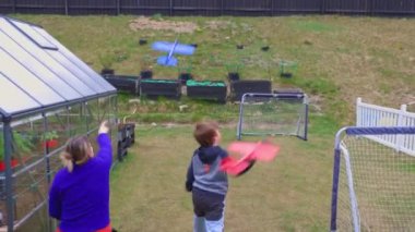 Büyükannem ve torunumun arka bahçede oyuncak uçaklarla oynadığı güzel bir manzara. İsveç.