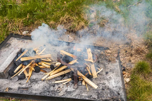 Close up view of starting fire on outdoor fireplace.