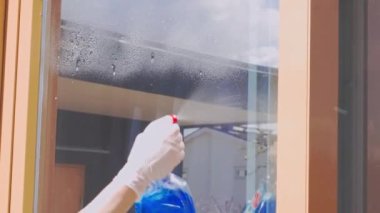 Evin penceresini temizleyen kadının yakın görüntüsü. İsveç.