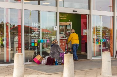 Süpermarketin girişindeki dilencinin yakın görüntüsü. Uppsala. İsveç. 05.12.2021.