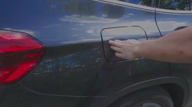 Elektrikli araba şarj istasyonuna kablo bağlayan adamın görüntüsü. İsveç. Uppsala. 06.24.2021.