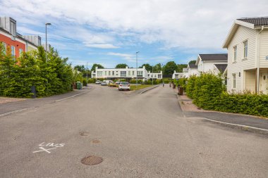 Modern Avrupa banliyösünün güzel manzarası. Yeni modern evler. Çocuklar bisiklete biniyor. İsveç. 