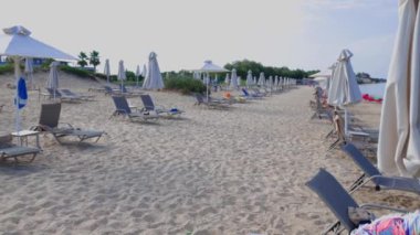 Güneşli bir yaz gününde kumsaldaki boş güneşli yatakların güzel manzarası. Yunanistan. 