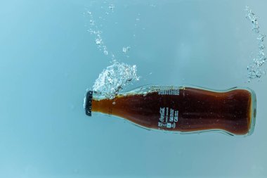 Coca Cola şişesinin suya düşüşünü yakından izle. İsveç. Uppsala. 08.03.2021.