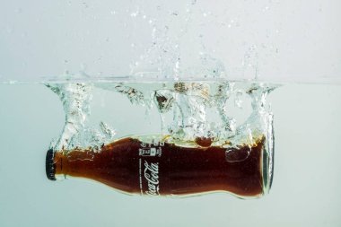 Coca Cola şişesinin suya düşüşünü yakından izle. İsveç. Uppsala. 08.01.2021.