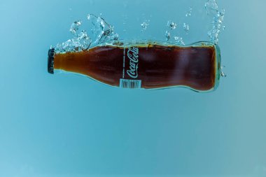 Coca Cola şişesinin suya düşüşünü yakından izle. İsveç. Uppsala. 08.06.2021.
