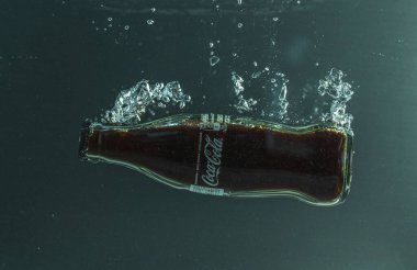 Coca Cola şişesinin suya düşüşünü yakından izle. İsveç. Uppsala. 08.01.2021.