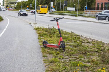 Güzel bir yaz şehri manzarası. Elektrikli scooter, arabalar ve yolda halk otobüsleri. İsveç. 