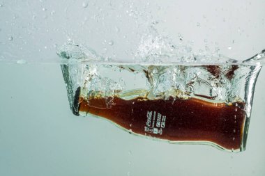 Coca Cola şişesinin suya düşüşünü yakından izle. İsveç. Uppsala. 08.24.2021.