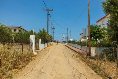 Tipik köy sokağı manzarası ve iki bisikletçi ve yol manzarası. Yunanistan.
